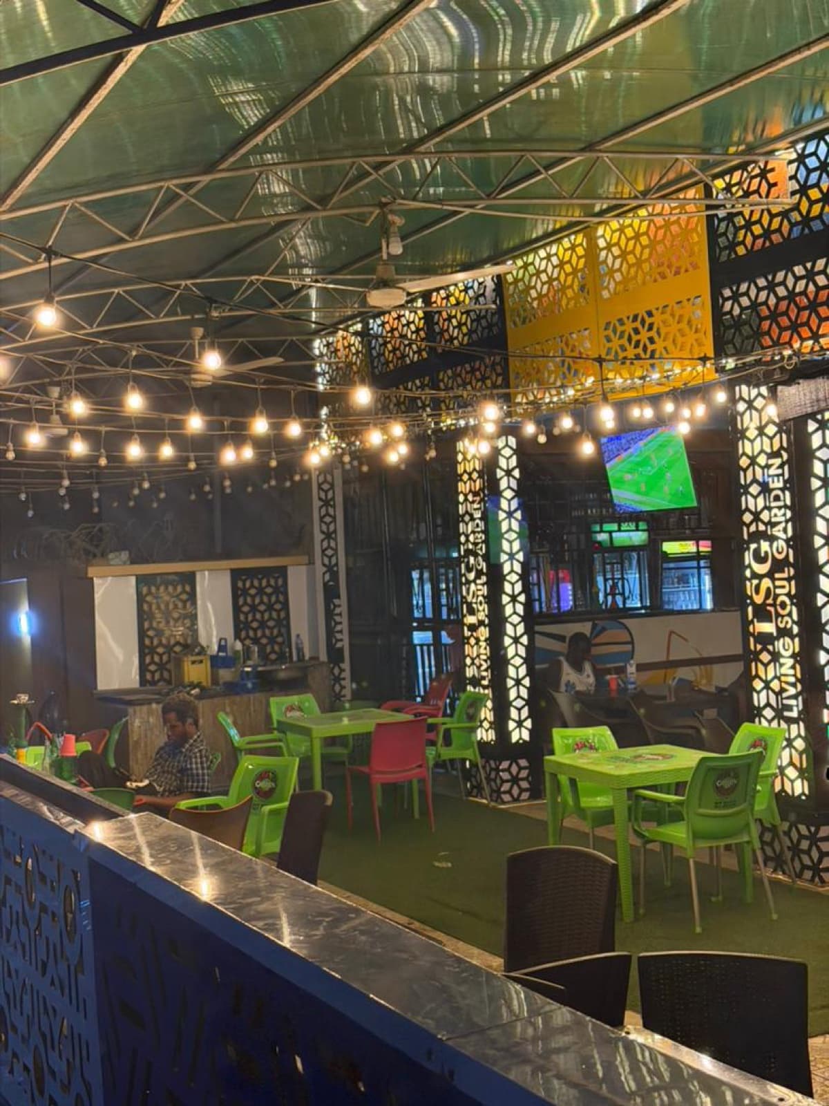 Bar and restaurant interior with string lights and TV screens